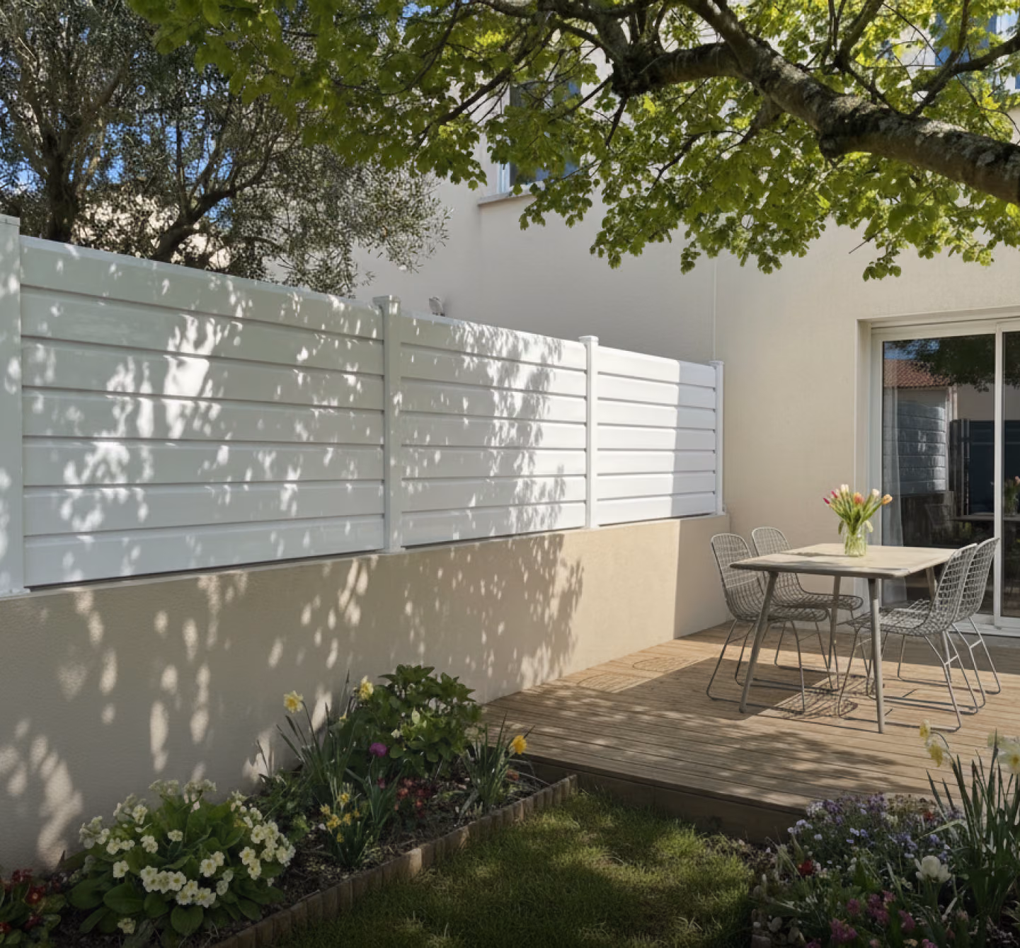 Clôture blanche posée sur un muret enduit, le long d'une terrasse